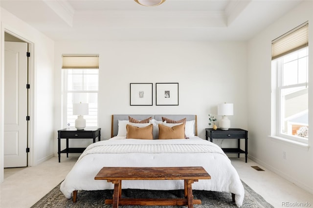 carpeted bedroom featuring crown molding and a tray ceiling