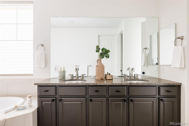 bathroom featuring vanity and a relaxing tiled tub