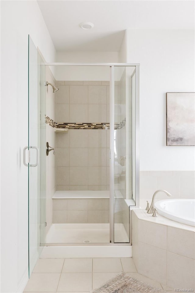 bathroom featuring shower with separate bathtub and tile patterned flooring