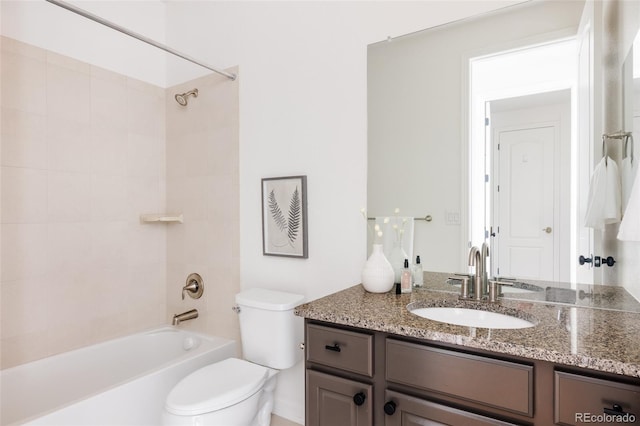 full bathroom featuring tiled shower / bath combo, vanity, and toilet