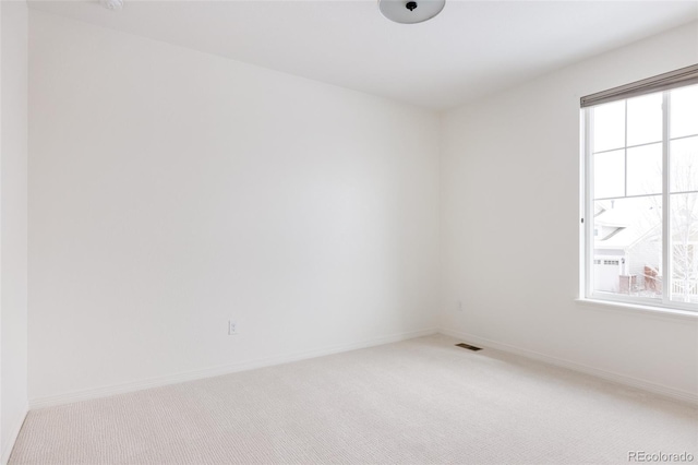 carpeted spare room featuring plenty of natural light