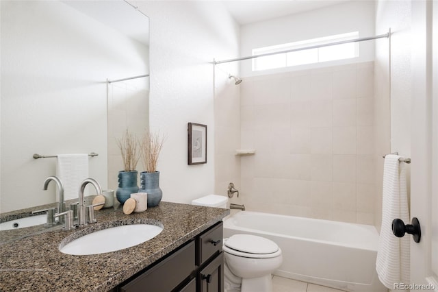 full bathroom featuring vanity, tile patterned flooring, toilet, and tiled shower / bath