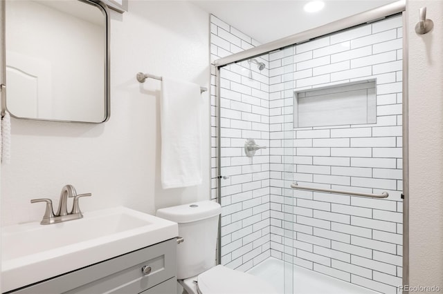 bathroom featuring vanity, an enclosed shower, and toilet