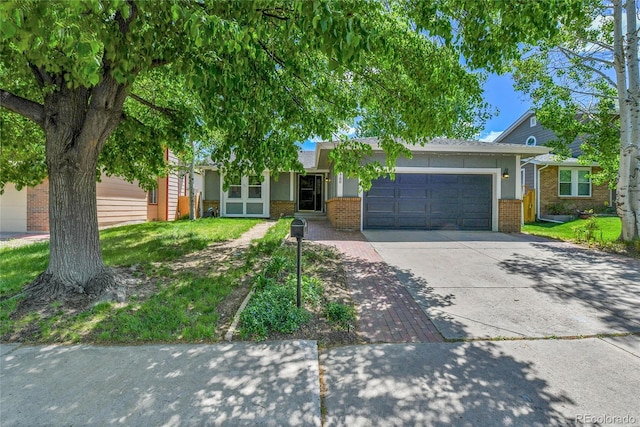 ranch-style house featuring brick siding, an attached garage, and concrete driveway