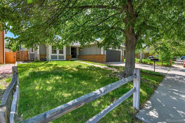 obstructed view of property with brick siding, concrete driveway, and a garage