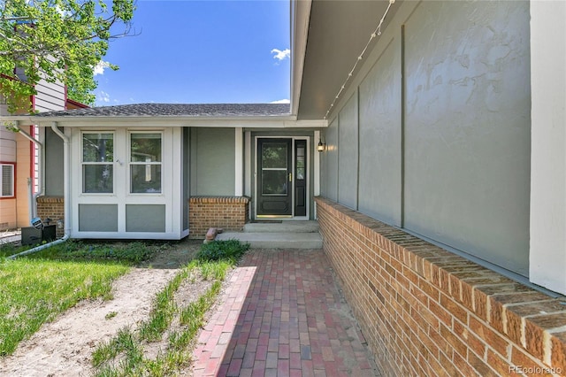 property entrance featuring brick siding and a chimney