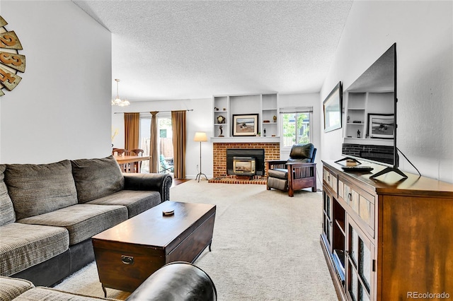 living room with a textured ceiling, plenty of natural light, light colored carpet, a brick fireplace, and a chandelier