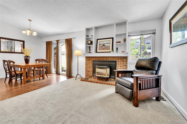 living room with healthy amount of natural light, a textured ceiling, a chandelier, a fireplace, and baseboards
