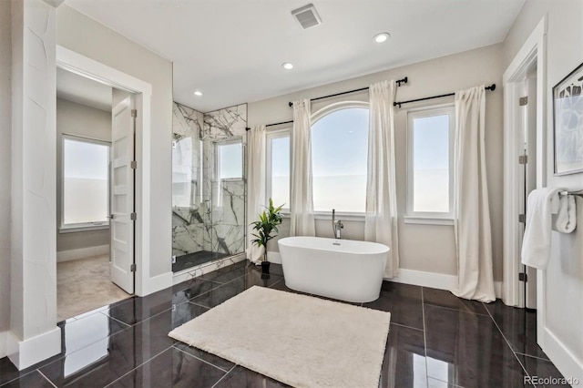 bathroom featuring tile patterned floors, a marble finish shower, baseboards, and a freestanding bath