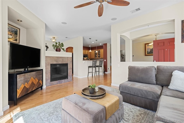 17808 E 104th Pl Unit C, Commerce City, CO 80022 - living room featuring light wood-type flooring, ceiling fan, and a fireplace