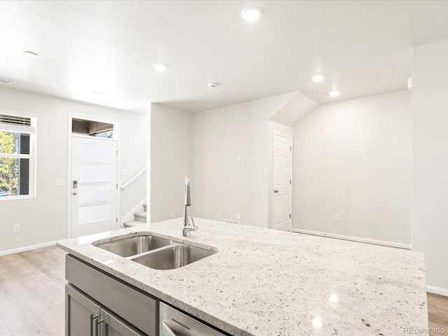 kitchen with light stone countertops, sink, light wood-type flooring, and gray cabinetry