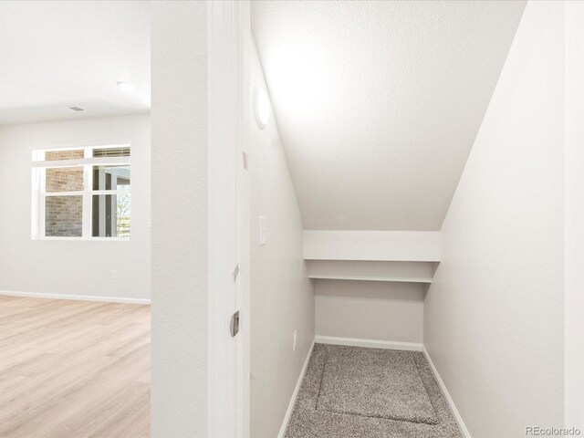 interior space featuring light hardwood / wood-style floors and lofted ceiling