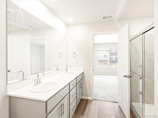 bathroom featuring vanity, hardwood / wood-style flooring, and a shower with shower door