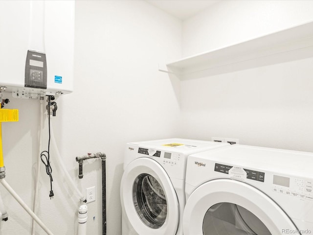 clothes washing area featuring washing machine and clothes dryer and tankless water heater