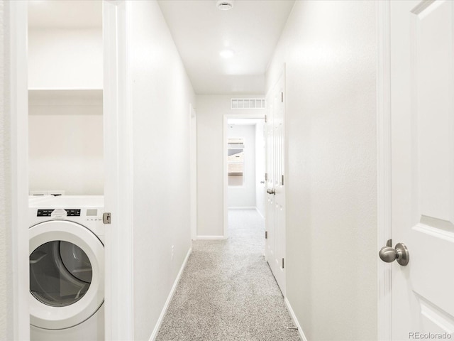 laundry area with washer / clothes dryer and light colored carpet