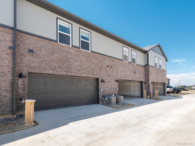 rear view of house with cooling unit and a garage