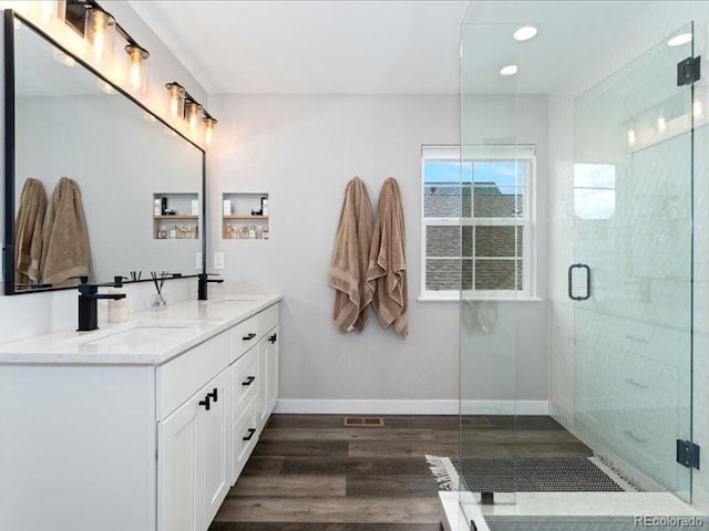 2833 Open Sky Way, Castle Rock, CO 80109 - bathroom with wood finished floors, a stall shower, baseboards, double vanity, and recessed lighting