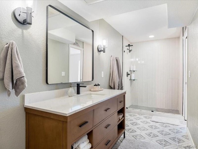 2833 Open Sky Way, Castle Rock, CO 80109 - bathroom featuring a tile shower, vanity, and a textured wall