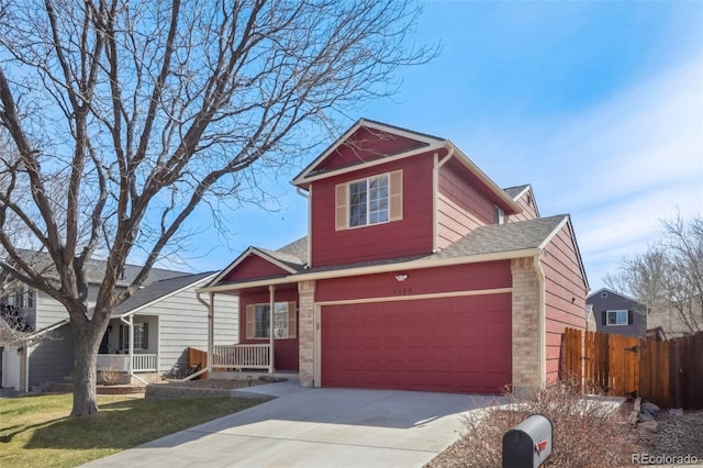 traditional home with a front lawn, a porch, driveway, and fence