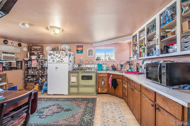 kitchen featuring white fridge, electric range oven, light hardwood / wood-style floors, and sink