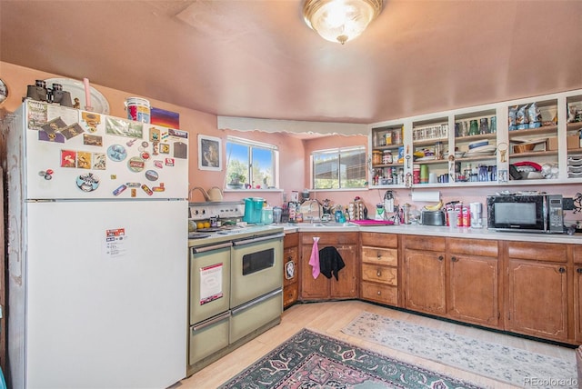 kitchen with sink, white refrigerator, and stainless steel electric range