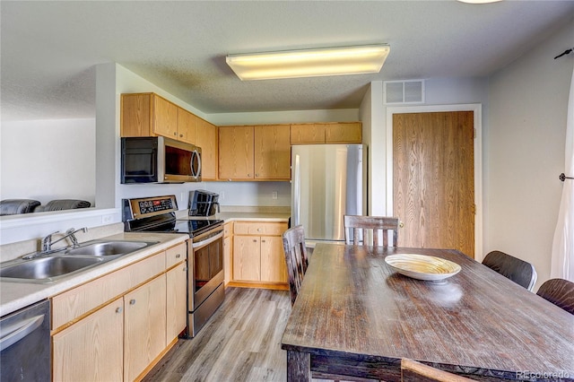 6330 Rockville Dr, Colorado Springs, CO 80923 - kitchen featuring appliances with stainless steel finishes, light wood-style floors, light brown cabinets, and light countertops