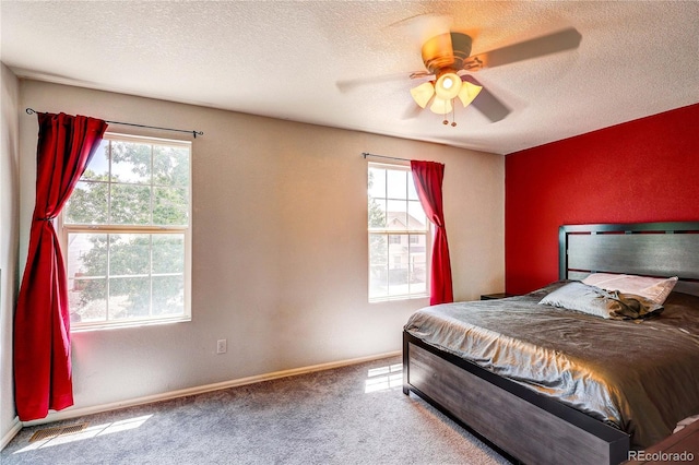 6330 Rockville Dr, Colorado Springs, CO 80923 - carpeted bedroom featuring multiple windows, a textured ceiling, and a ceiling fan