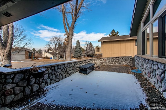 snow covered patio with a residential view