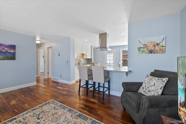living room with recessed lighting, baseboards, visible vents, and dark wood finished floors