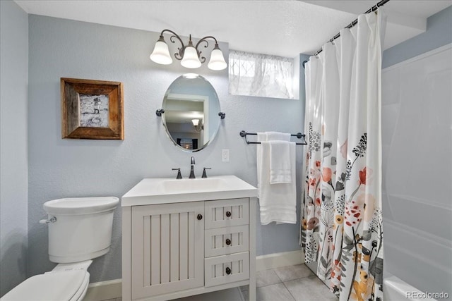 full bath featuring a textured wall, vanity, toilet, tile patterned floors, and baseboards