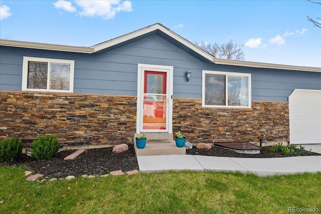 view of front of property with a garage and stone siding