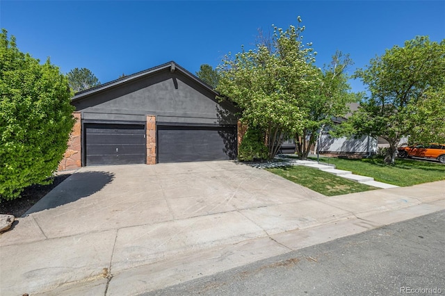 single story home featuring concrete driveway, a garage, and stucco siding