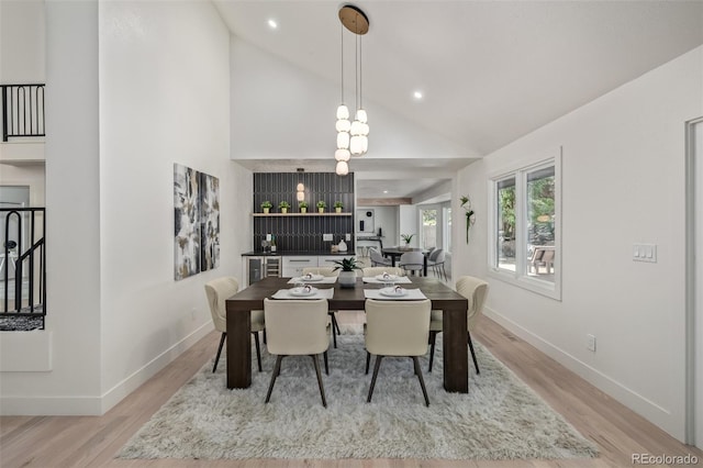 dining area featuring light wood-style floors, baseboards, recessed lighting, and high vaulted ceiling