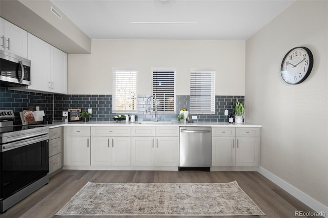 2620 S Delaware St Unit 2, Denver, CO 80223 - kitchen with stainless steel appliances, light wood finished floors, light countertops, and backsplash