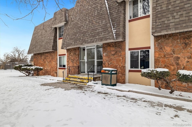 view of snow covered back of property