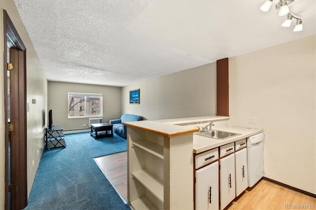 kitchen with white dishwasher, a textured ceiling, white cabinets, sink, and kitchen peninsula