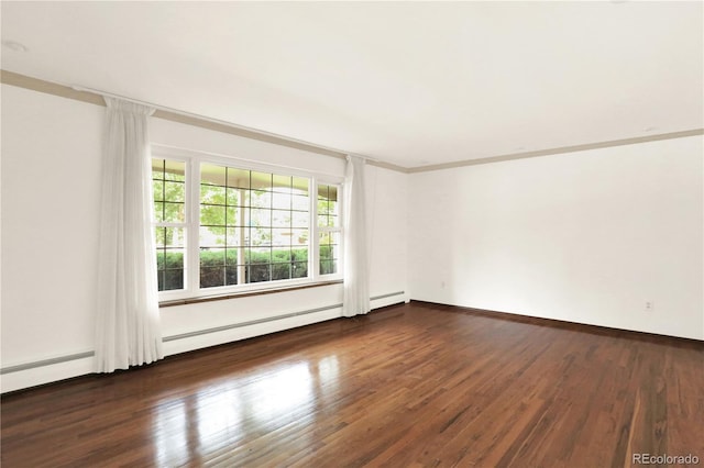 spare room with ornamental molding, baseboard heating, and dark hardwood / wood-style floors