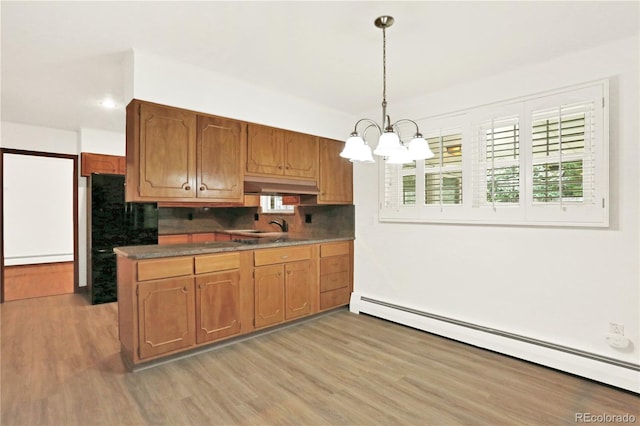 kitchen with pendant lighting, backsplash, a chandelier, a baseboard radiator, and light wood-type flooring