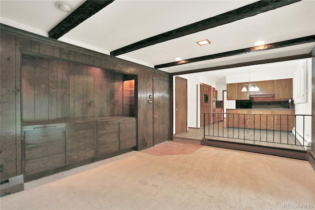 interior space with wooden walls, a chandelier, beamed ceiling, and light colored carpet