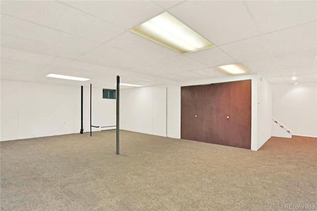 basement featuring a drop ceiling and carpet