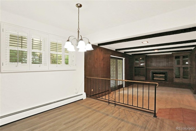 unfurnished dining area with a brick fireplace, wood-type flooring, beam ceiling, a baseboard radiator, and a notable chandelier