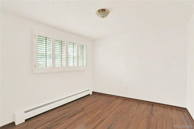 unfurnished room featuring baseboard heating and hardwood / wood-style flooring