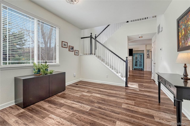 entrance foyer featuring stairs, baseboards, and wood finished floors