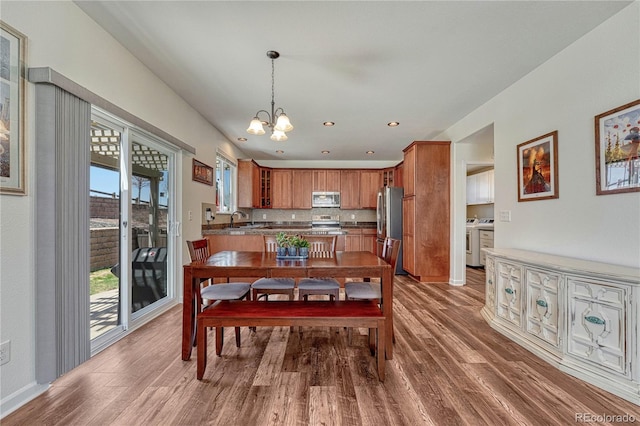 dining space featuring a chandelier, recessed lighting, washer / dryer, and wood finished floors