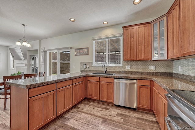 kitchen with stainless steel appliances, a peninsula, and brown cabinets
