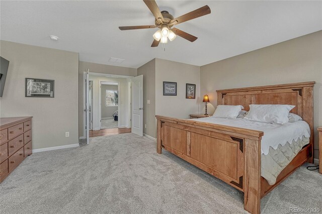 bedroom featuring light carpet, visible vents, baseboards, and a ceiling fan