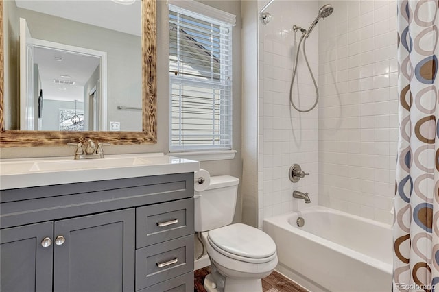full bath with vanity, shower / bath combination with curtain, toilet, visible vents, and wood finished floors