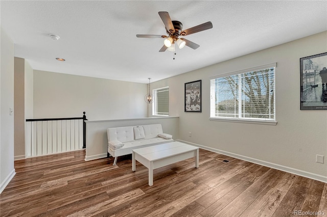 sitting room with wood finished floors, ceiling fan, and baseboards