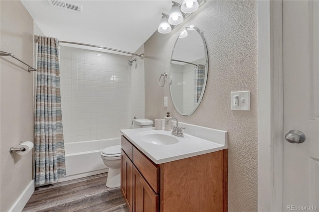 bathroom featuring shower / tub combo, vanity, toilet, visible vents, and wood finished floors