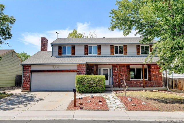 traditional-style home featuring a chimney, fence, concrete driveway, and brick siding